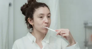 Banyoda dişlerini fırçalayan kadın