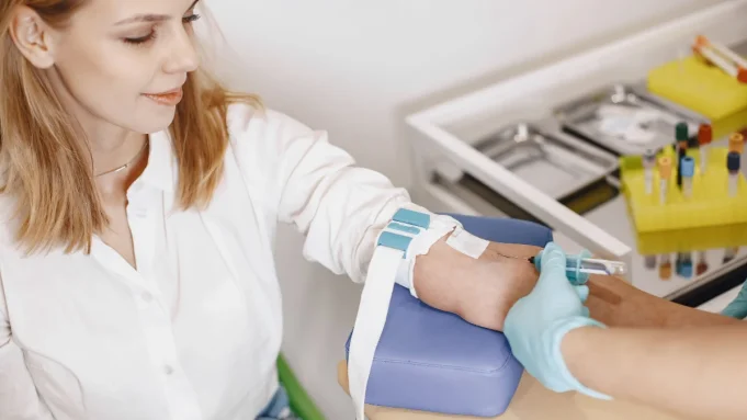 HbA1c nedir Laboratuvarda HbA1c testi için koldan kan örneği verilen kadın
