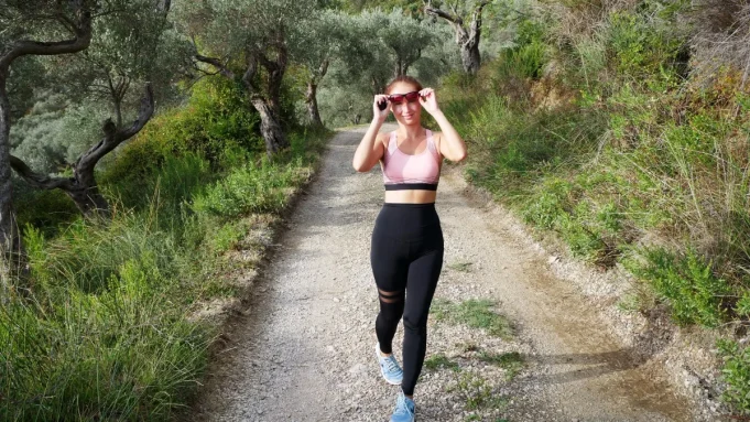 İnterval yürüyüş Doğa yolunda spor kıyafetiyle tempolu yürüyen kadın
