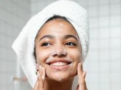 Perioral Dermatit Neden Olur ve Ağız Çevresindeki Kızarıklık Nasıl Yatışır Yüzünü yumuşak bir temizleyiciyle yıkayan, başında havlu olan genç kadın