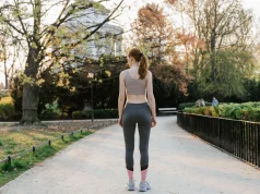 Yürüyüşe Başlarken Süre, Tempo ve Ayakkabı Nasıl Seçilir Spor kıyafetleriyle parktaki yürüyüş yolunun başında duran ve yürüyüşe başlamaya hazırlanan kadın